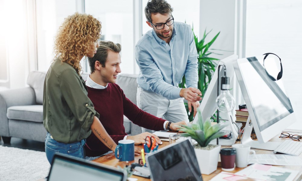 Team collaborating at computer desk