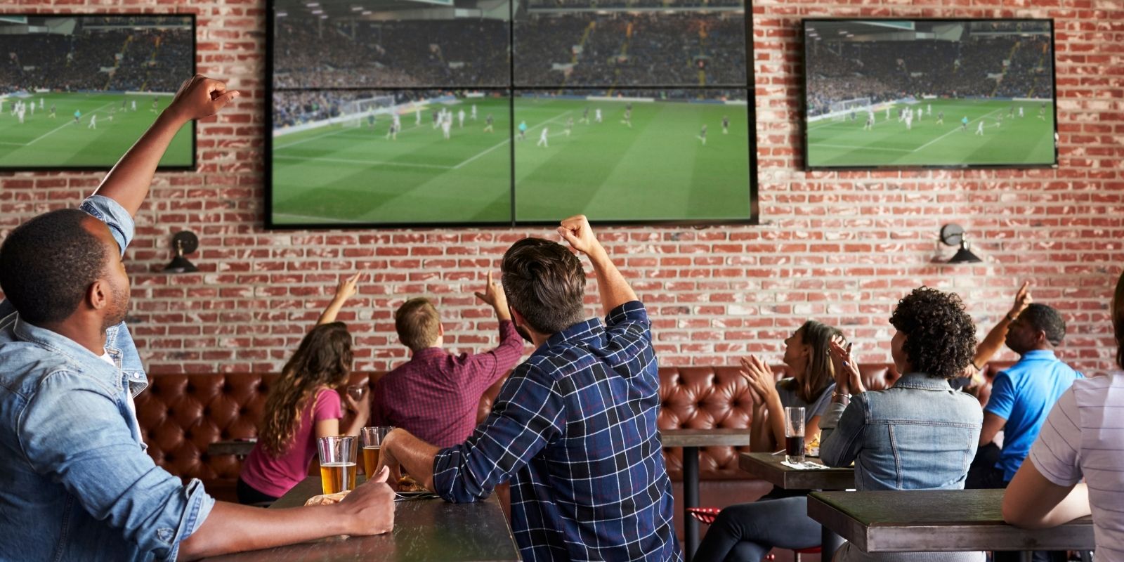 Crowd watches soccer match in bar