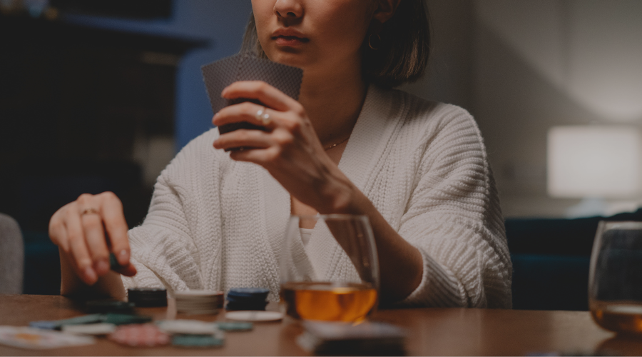 Woman holding poker cards at table